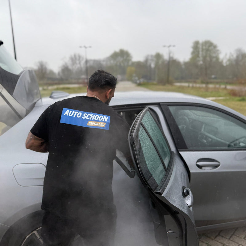 Stoomreiniging van een auto, de damp slaat om de wagen heen